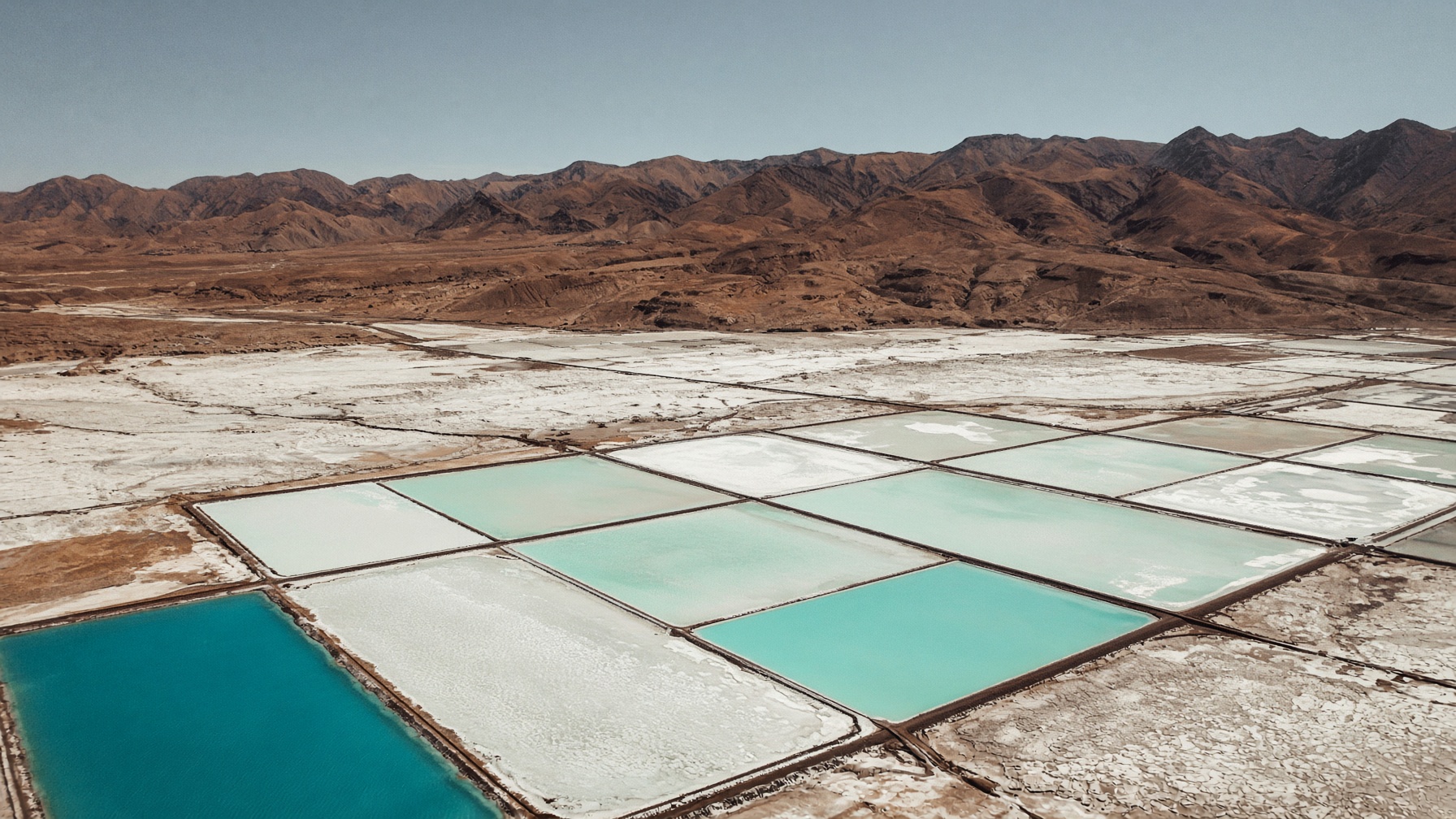 Pozas de evaporación de litio en el Salar de Atacama, rectángulos turquesa sobre costra de sal.